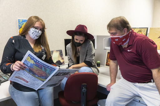 Kimberly Wethal (left) discusses a piece with her colleagues.