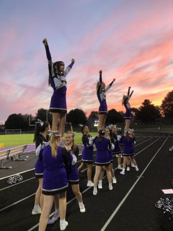 The cheer team performs at a home football game