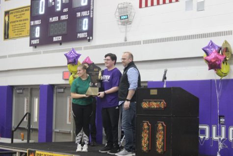 Senior Student Senate members Evan Loftus (middle) and Keilley Riddle (left) are awarded the 2023 Spirit of Excellence Trophy from Executive Director Bjorn Berg. 