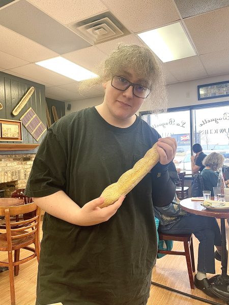 Travis Ryan holds his newfound baguette with the delicacy of a newborn baby.