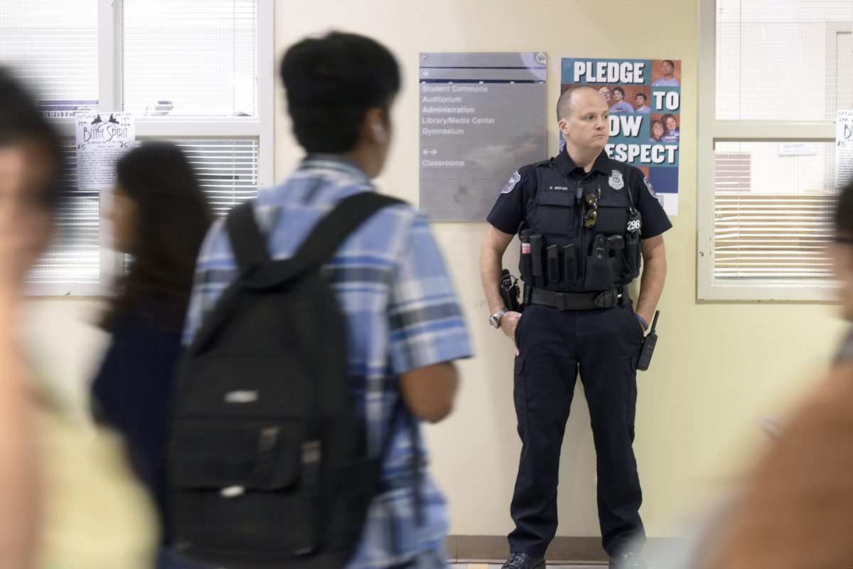 ADVANCE FOR WEEKEND EDITIONS OCT. 29-30 - In this Oct. 21, 2016 photo, Greeley Police Officer Steve Brown stands in the hallway during passing periods at Northridge High School, 7001 Grizzly Dr., in Greeley, Colo. While school resource officers, like Brown, are expected to handle responsibilities like any police officer they're faced with unique challenges working day-to-day in schools.(Joshua Polson/The Greeley Tribune via AP)