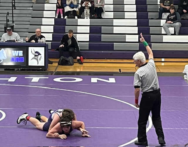 Nielsen makes a call working as a veteran referee during a high school wrestling match.